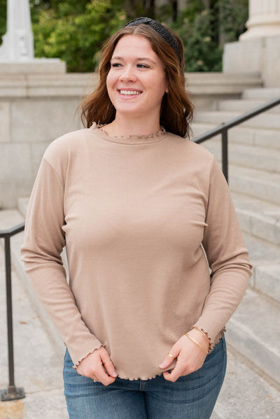 Plus size tan ruffle ribbed top with ruffle stitching on the neck and cuffs