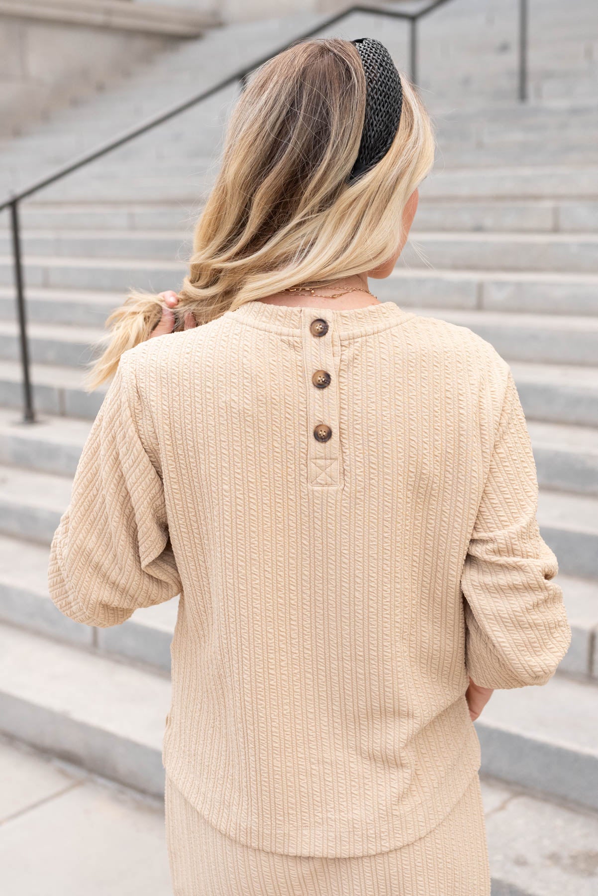 Back view of the beige textrued top with buttons