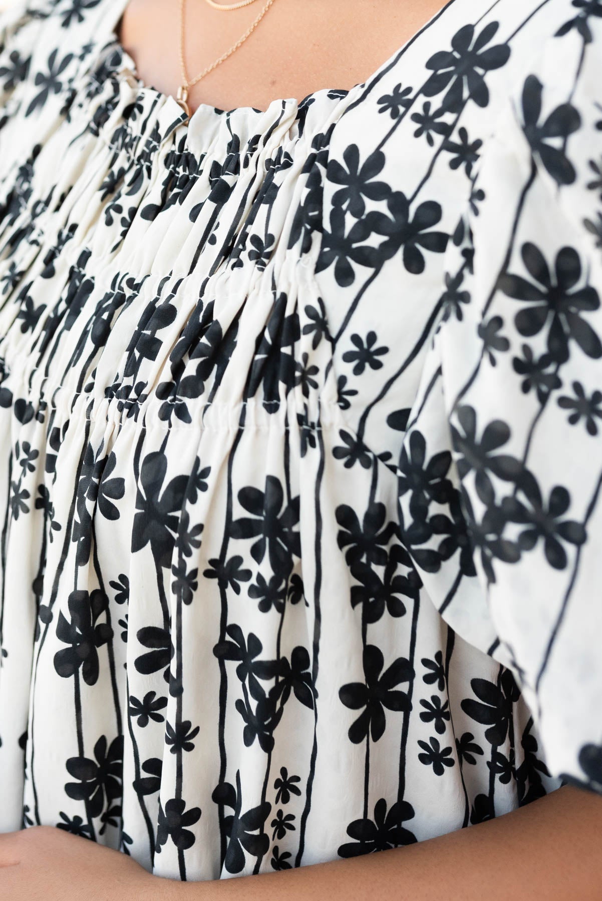 Close up of the neck and fabric on the cream black floral dress