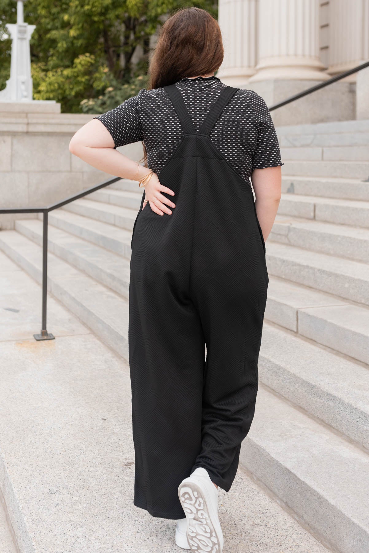 Back view of the plus size black textured overalls