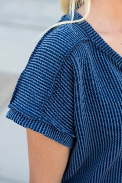 Close up of the fabric and sleeve on the navy ribbed top