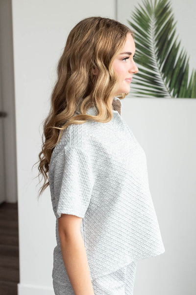 Side view of the heather grey collared knit top