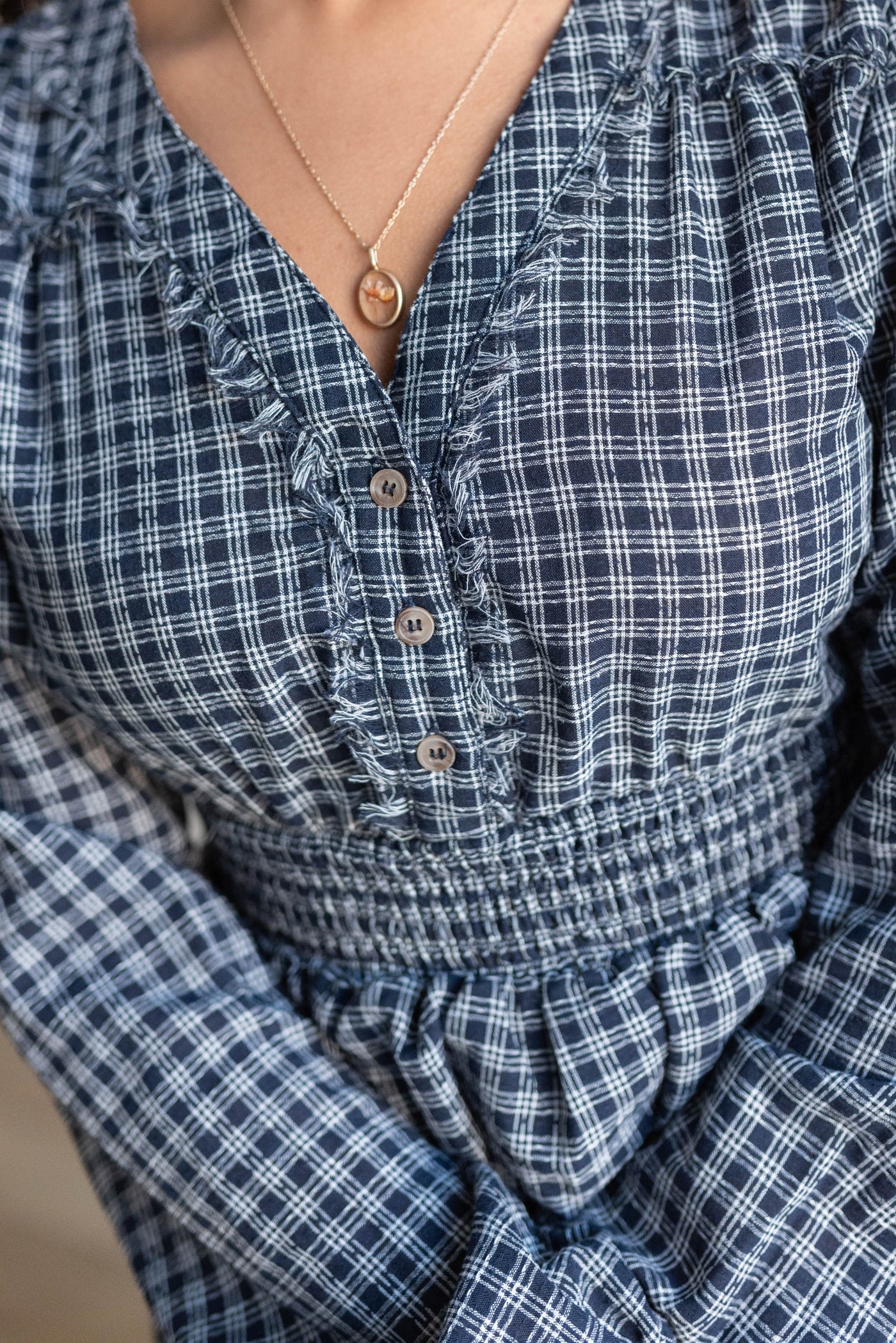 Close up of the buttons and fabric on the navy plaid dress