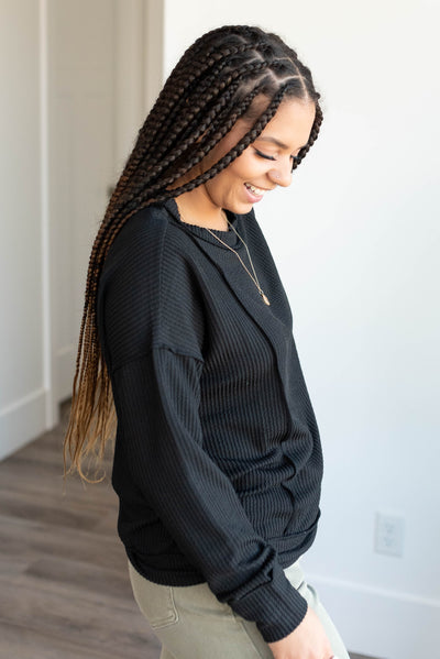 Side view of the black ribbed long sleeve top