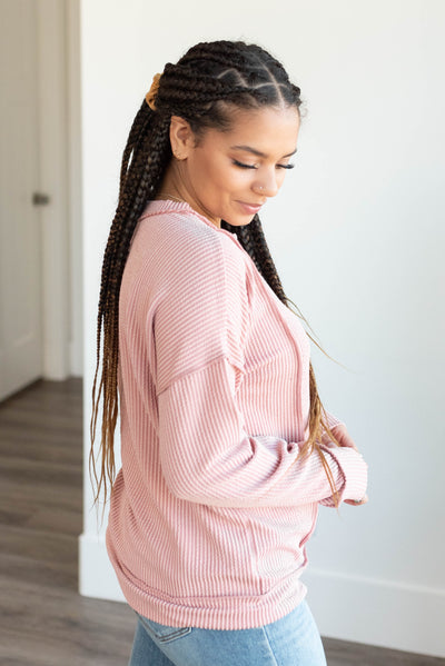 Side view of the light rose ribbed long sleeve top