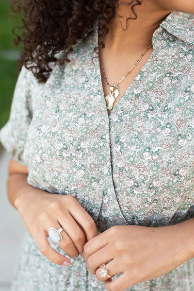 Close up of the fabric and neckline on the olive floral midi dress