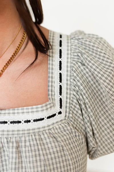 Close up of the trim of the neck on the black checkered dress