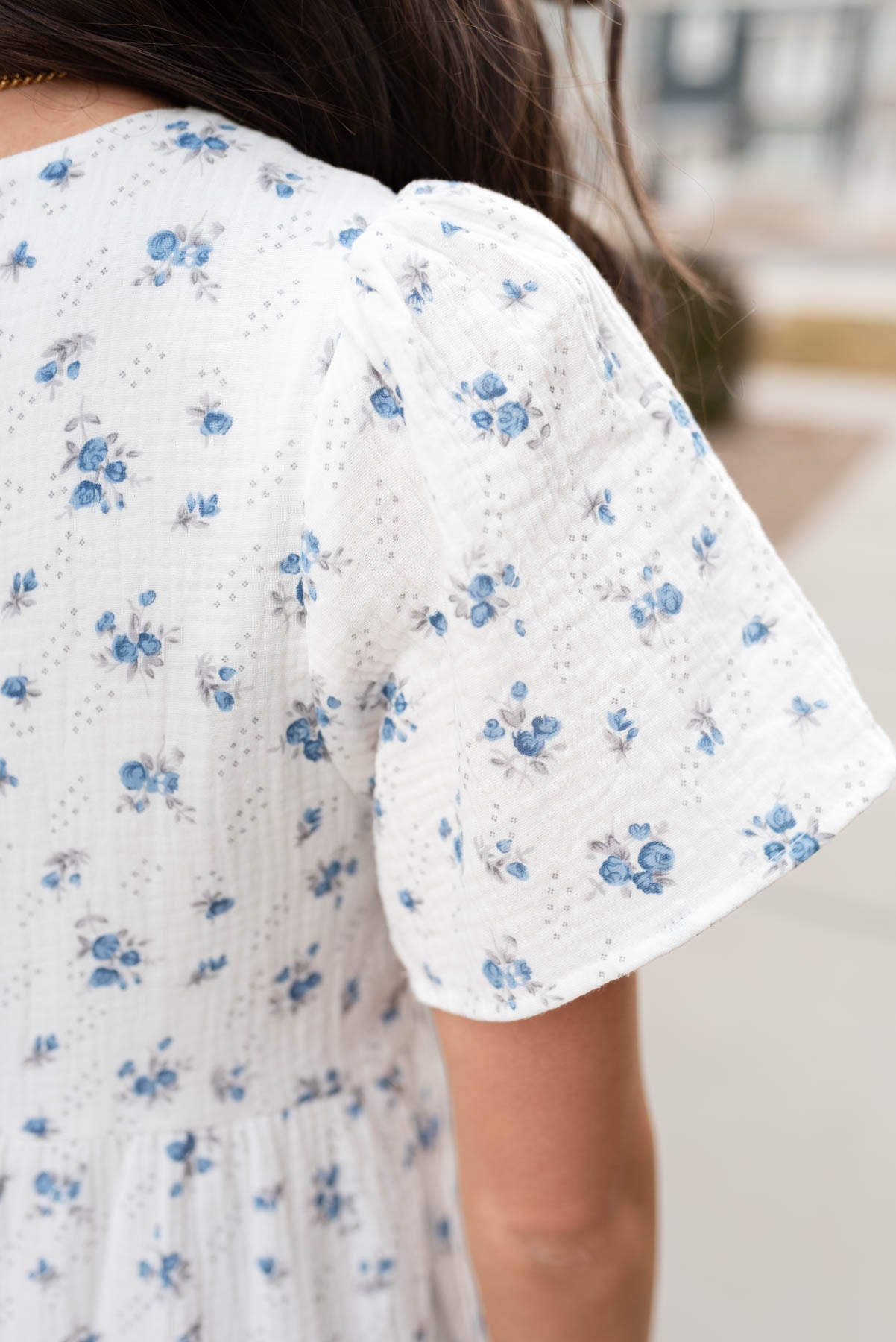 Close up of the fabric and sleeve on the blue floral guaze tiered dress