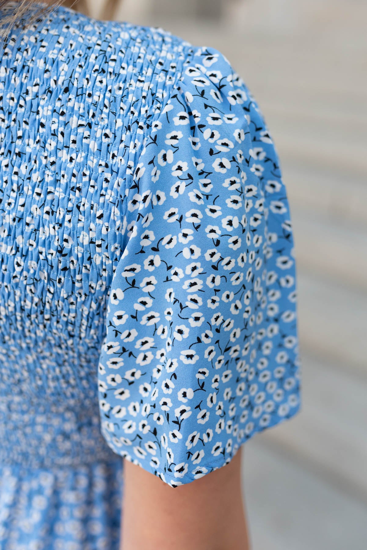 Close up of the fabric and sleeve on the blue floral v-neck dress