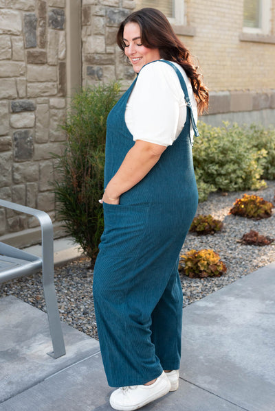 Side view of the plus size deep aqua corduroy overalls