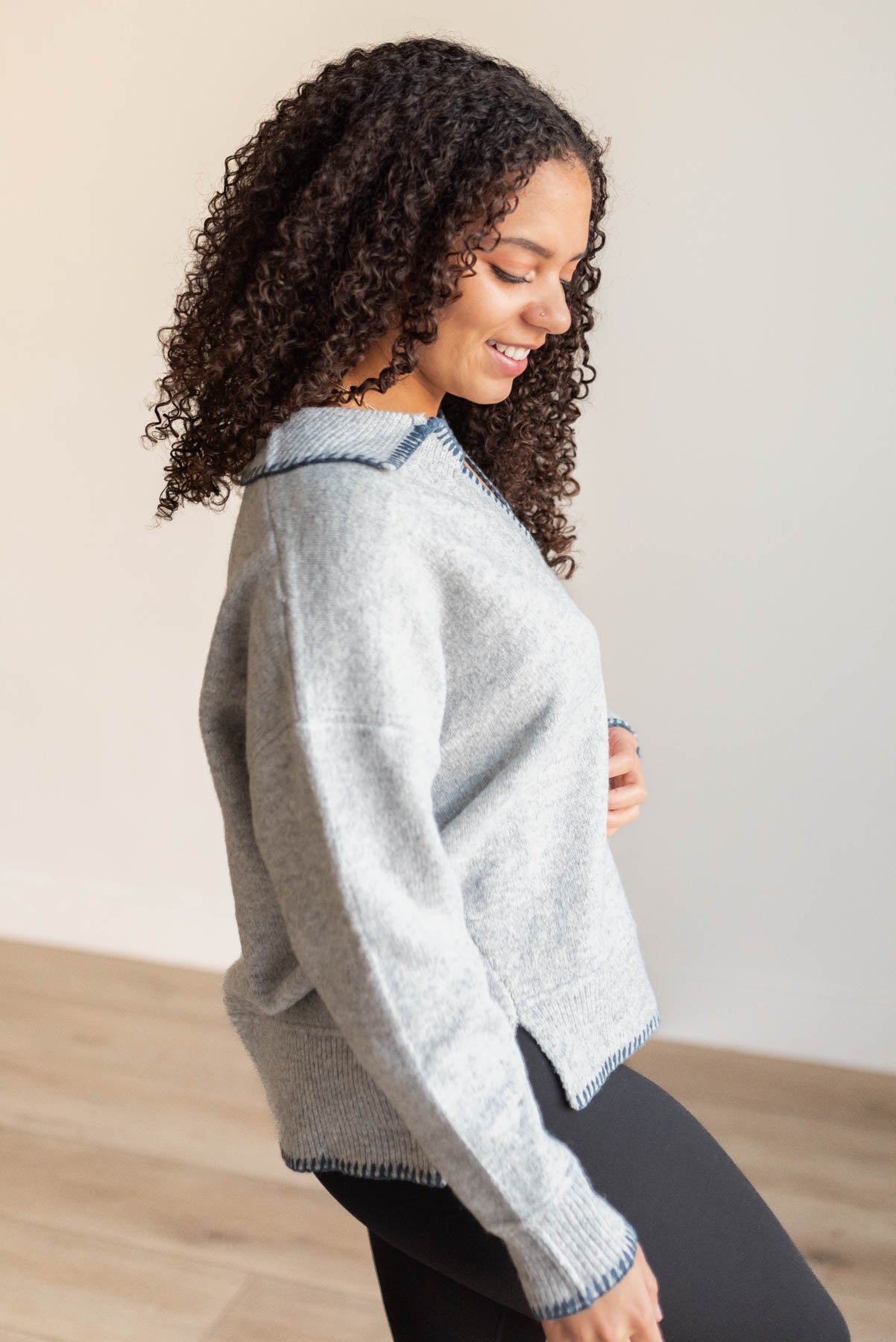 Side view of the navy stitched knit sweater