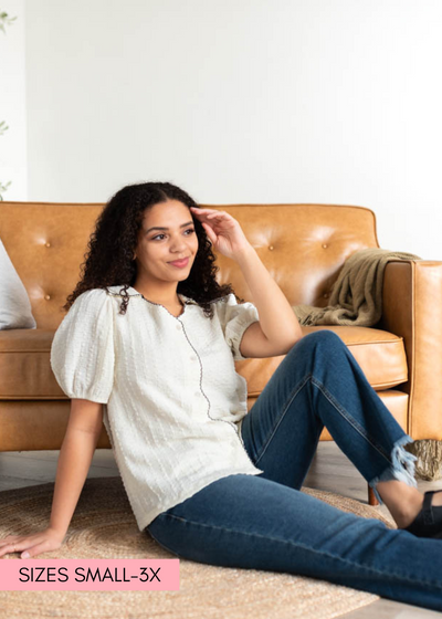 Cream collared top that buttons up and has short sleeves