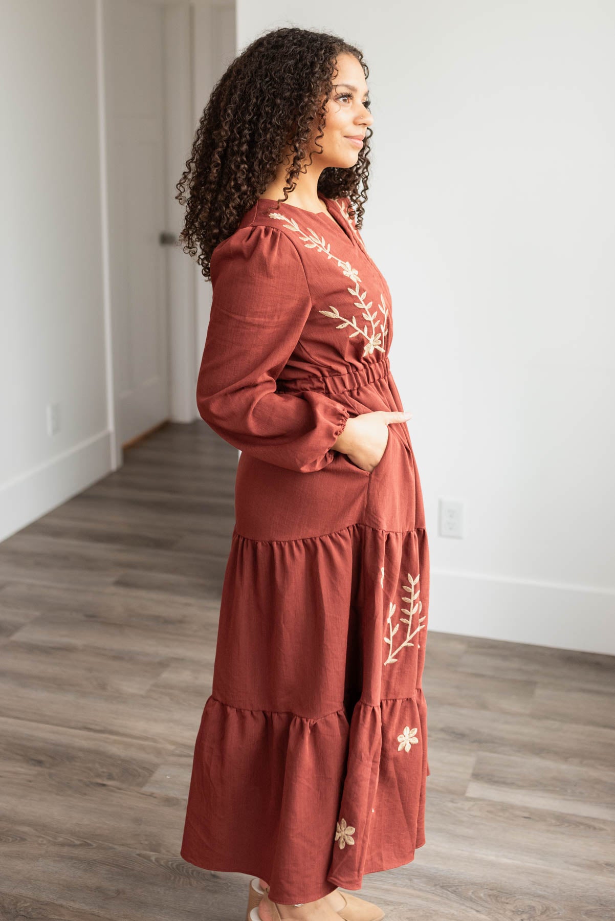 Side view of the burgundy embroidered floral dress with pockets