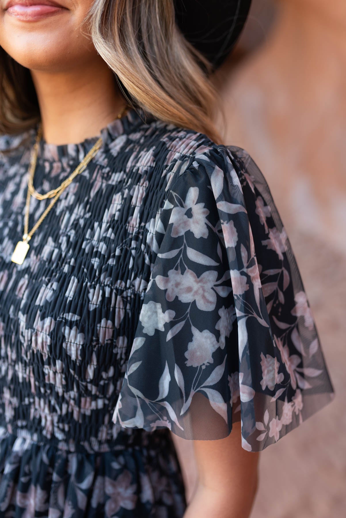 Close up of the sleeve of a black floral dress