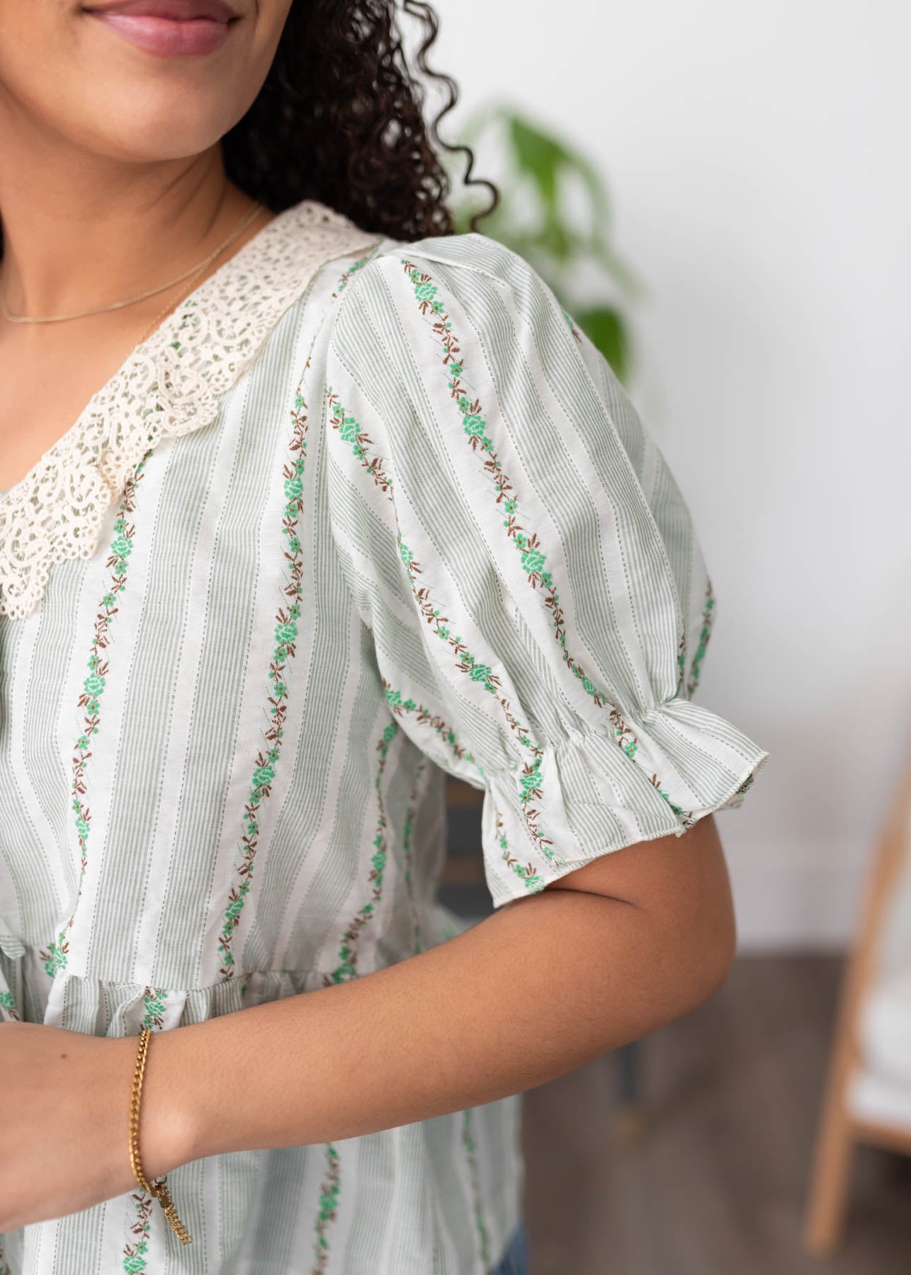 Close up of the lace on the collar of the green lace top