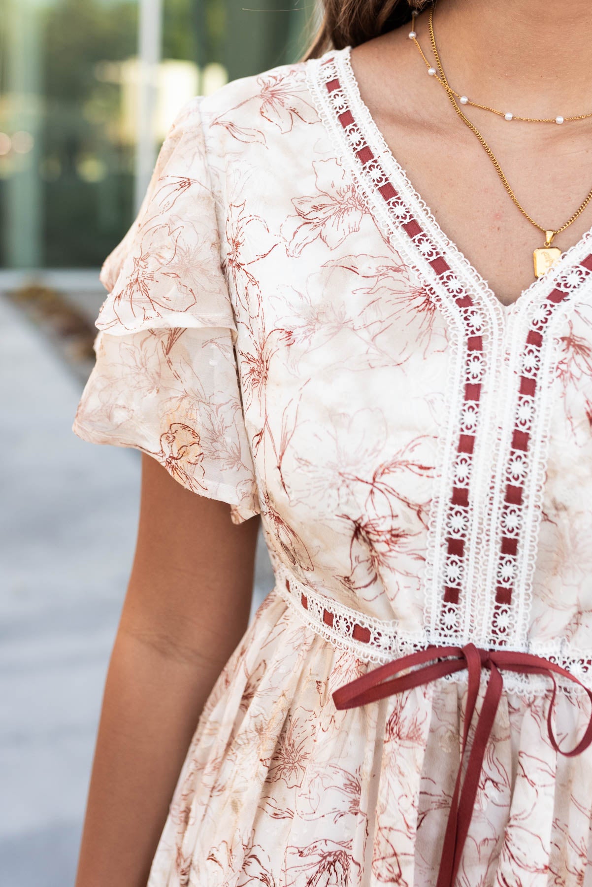 Close up of the fabric, ribbon and lace detail on the burgundy floral lace dress