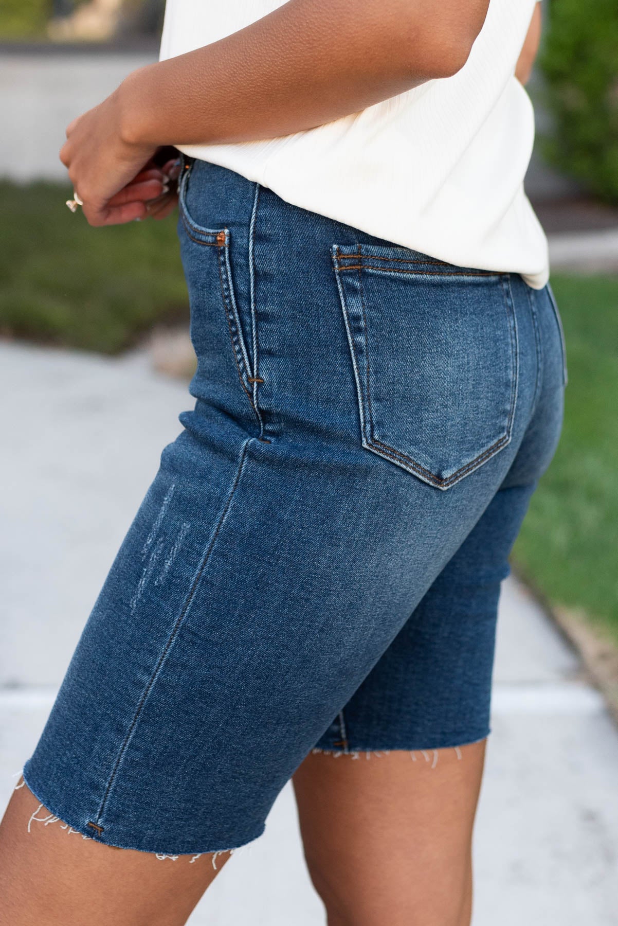 Side view of the indigo shorts with raw hem