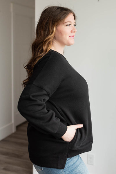 Side view of the plus size black pocketed sweater