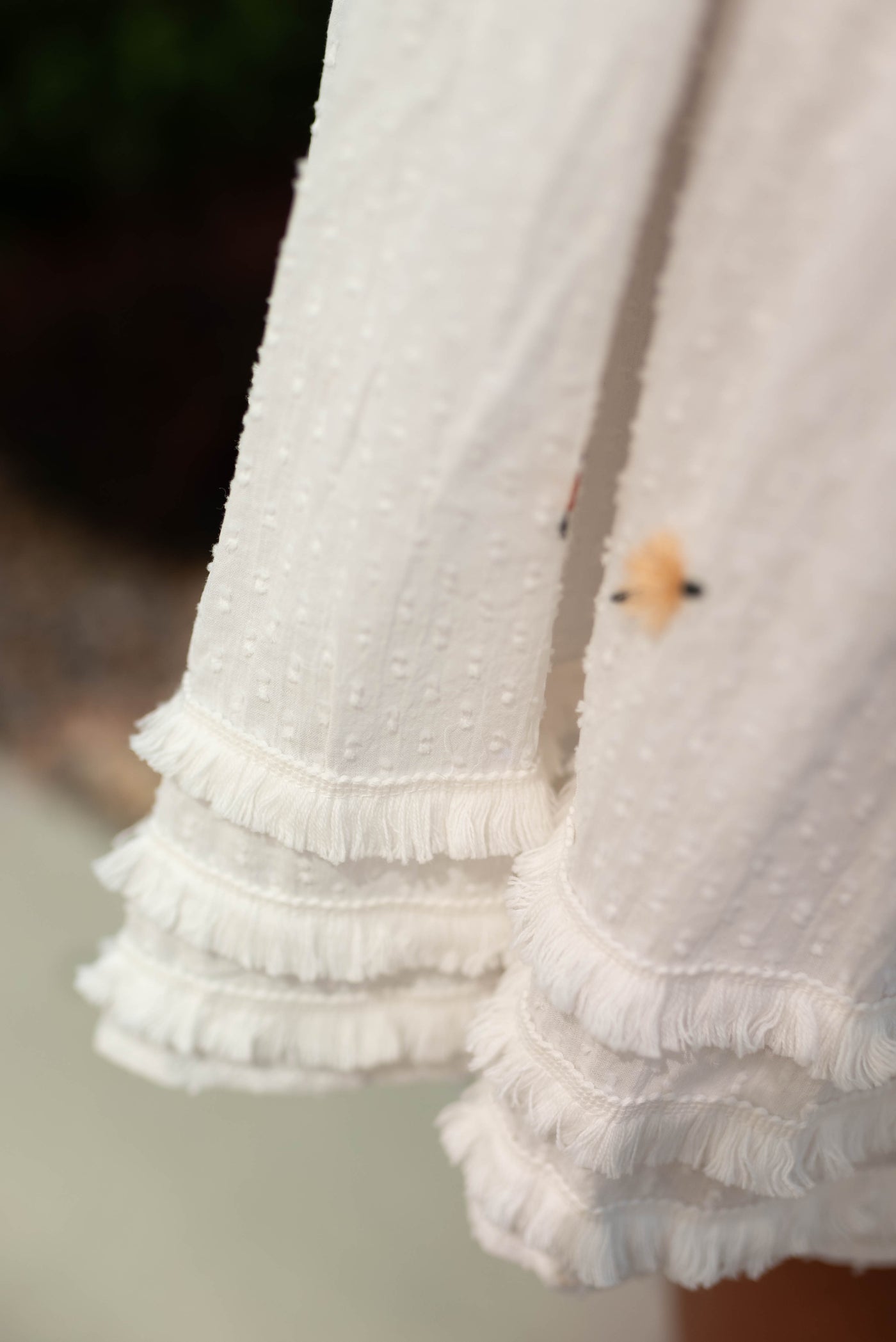 Fringe on the skirt of a white dress