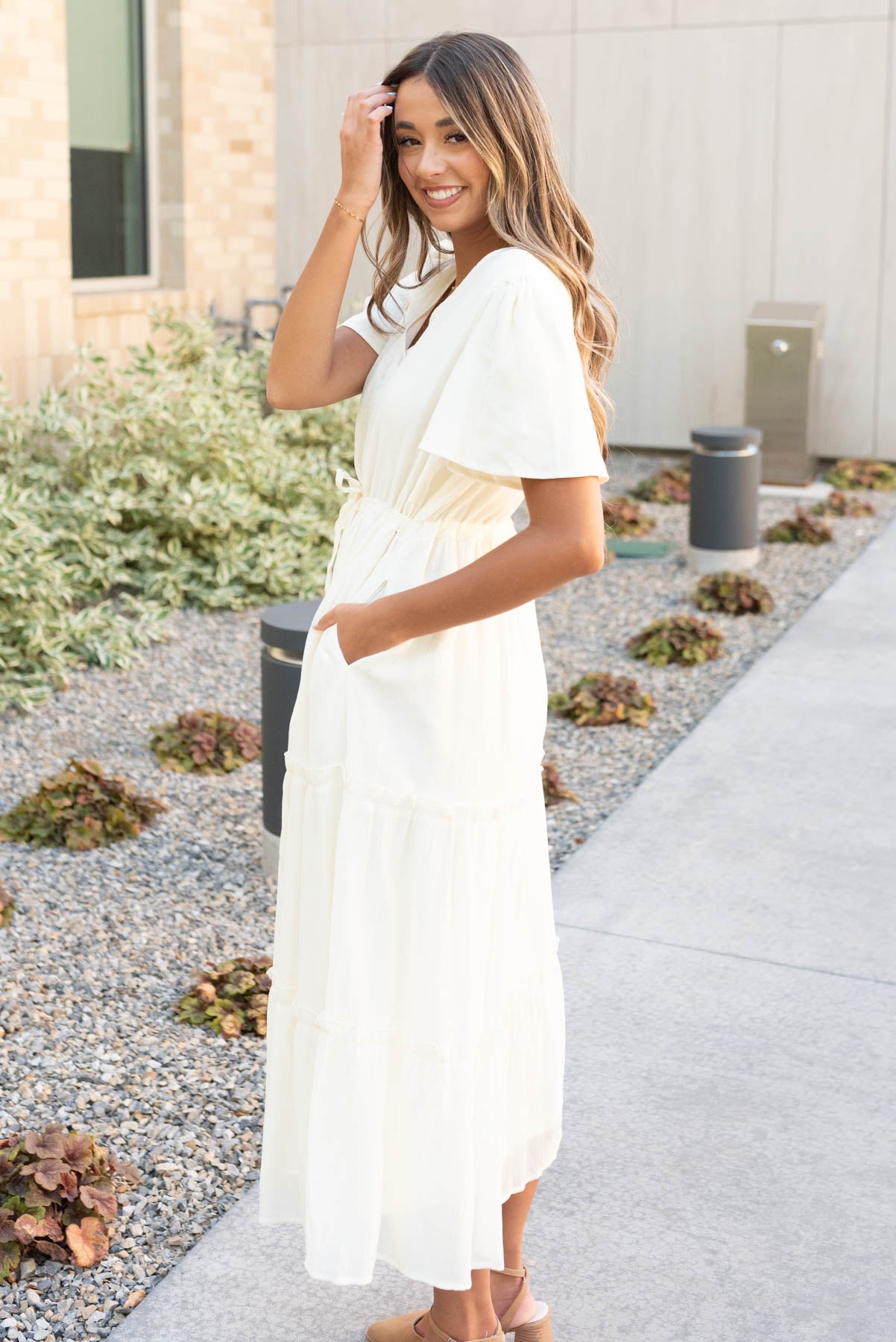 Side view of the cream button down dress