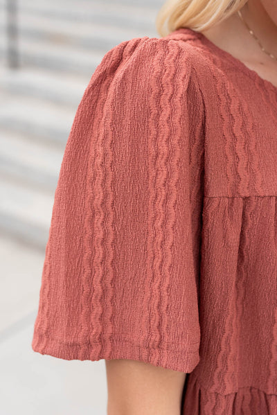 Close up of the fabric and sleeve on the marsala textured ress