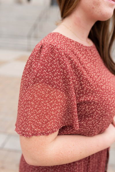 Close up of the fabric on the plus size burgundy pleated tie dress