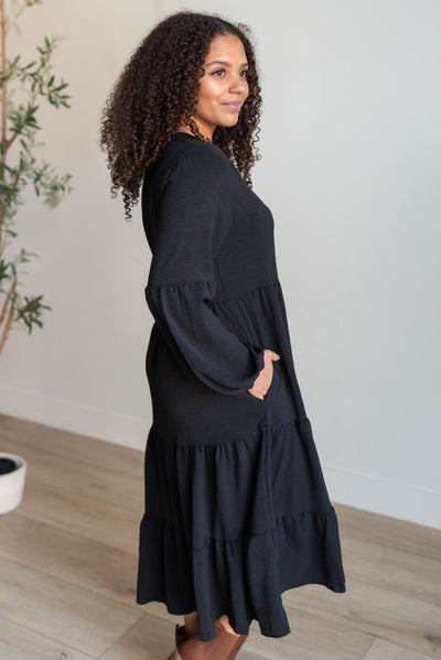 Side view of the black tiered dress with pocket