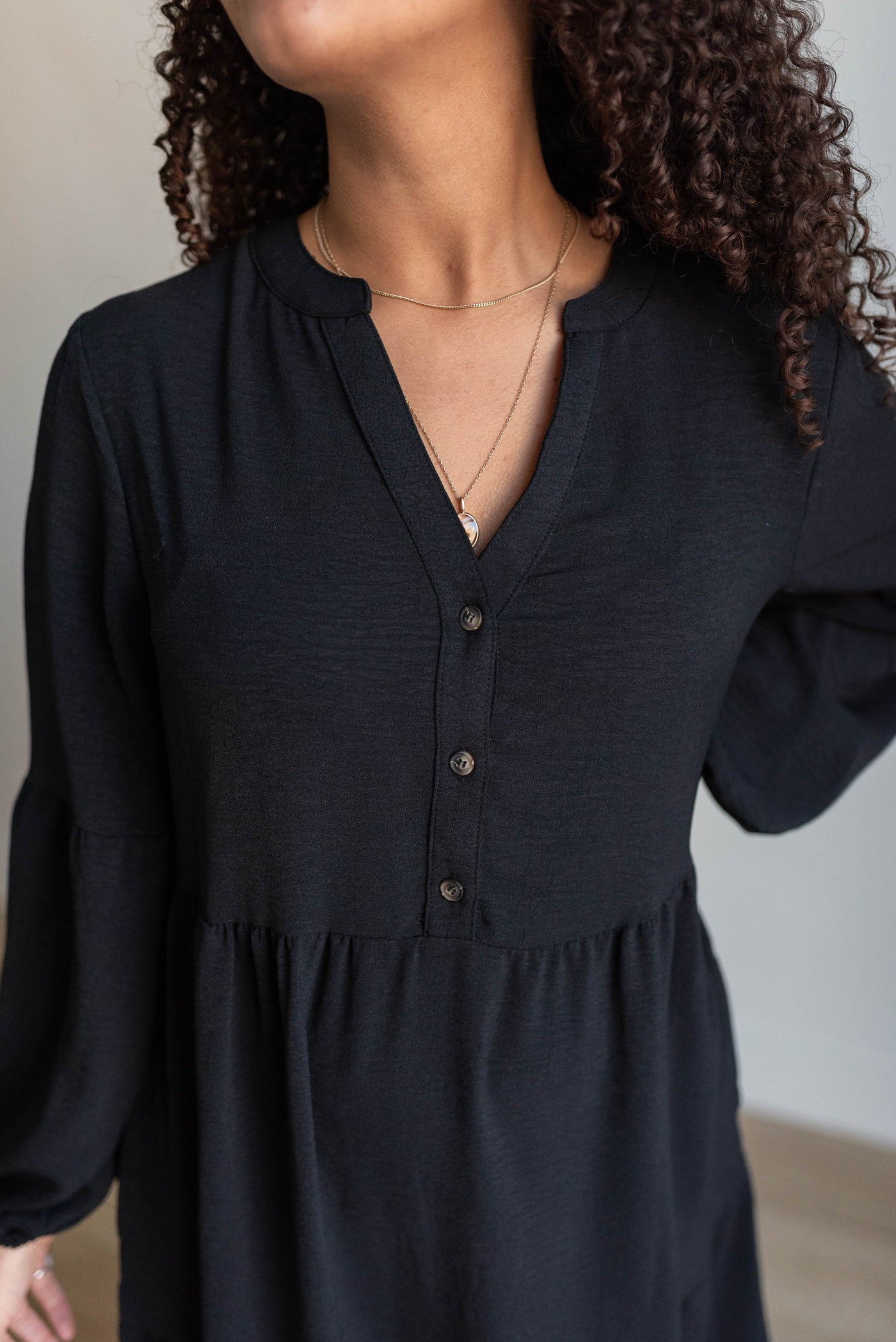 Close up of the bodice and buttons on the black tiered dress