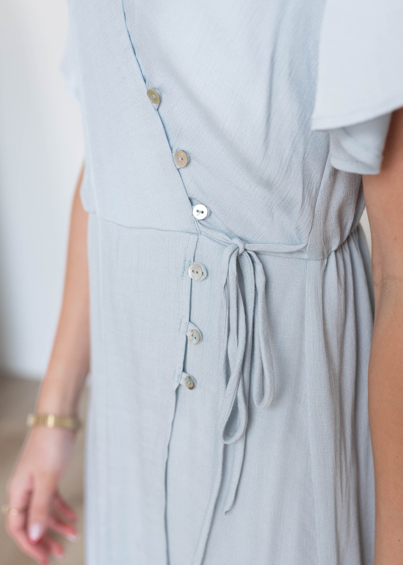 Close up of the buttons on the dusty blue wrap dress