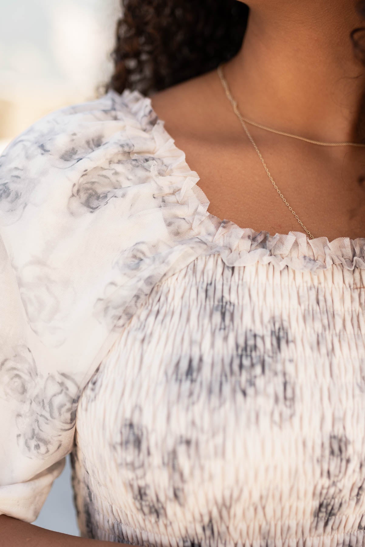 Close up of the fabric and trim on the grey floral tiered dress