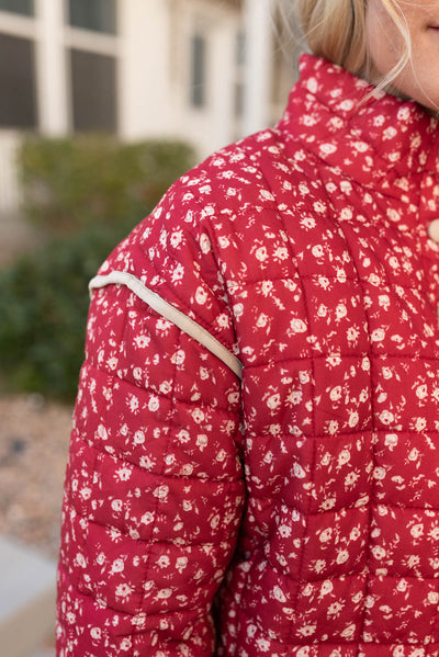 Close up of the trim on the shoulder on the red floral quilted jacket