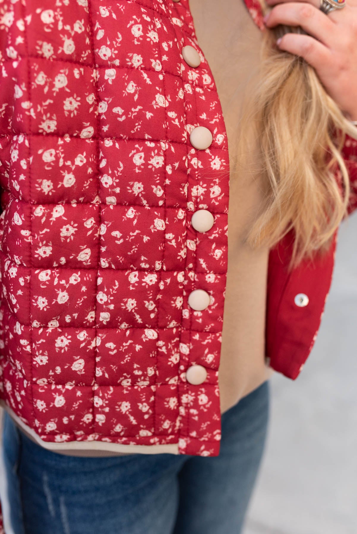 Close up of the fabric and snaps on the red floral quilted jacket