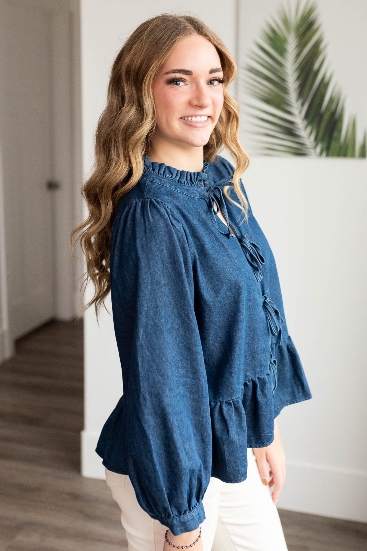 Side view of the dark denim bow top