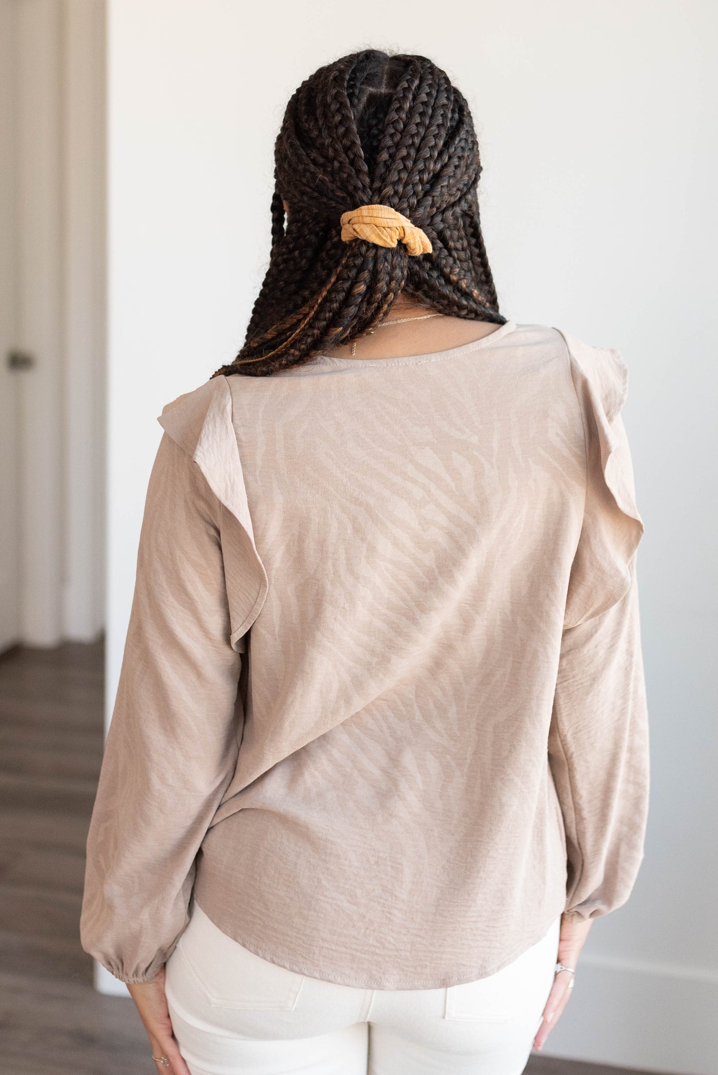 Back view of the beige long sleeve top